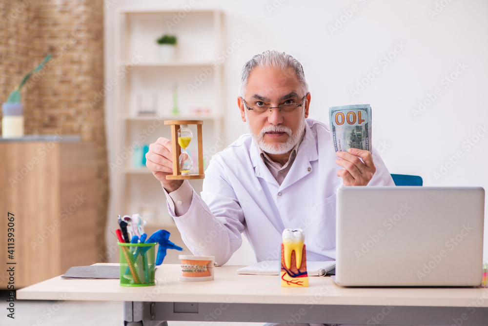 Old male dentist in time management concept Old male dentist in time management concept