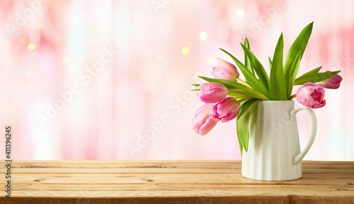 Fototapeta Naklejka Na Ścianę i Meble -  Beautiful tulip flower bouquet on wooden table over pink bokeh background. Valentine's day or mother's day concept