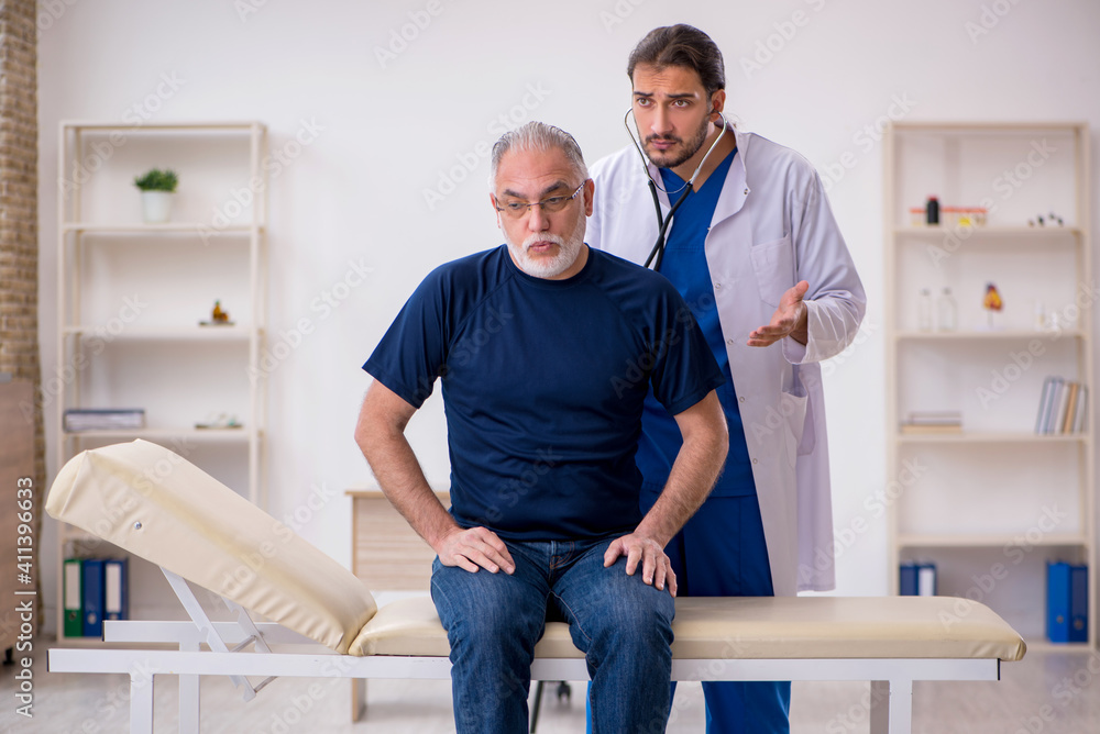 Obraz premium Old male patient visiting young male doctor