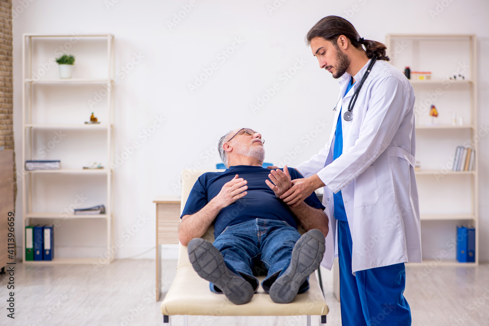 Obraz premium Old male patient visiting young male doctor chiropractor