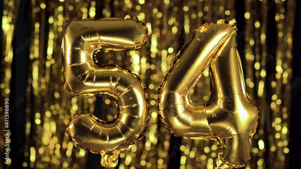 The golden number 54 fifty four is made from an inflatable balloon on a yellow background. One of the complete set of numbers. Birthday, anniversary, date concept The golden number 54 fifty four is made from an inflatable balloon on a yellow background. One of the complete set of numbers. Birthday, anniversary, date concept