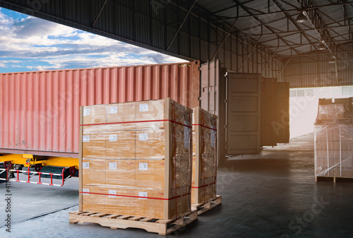 Cargo shipment loading for truck. Freight truck for delivery service. Logistics and transportation. Warehouse dock load pallet goods into container truck. Stacked boxes wrapped plastic on pallet rack.