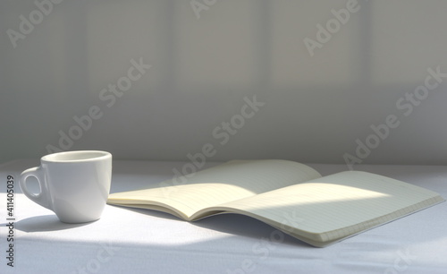 An open notebook and white coffee cup on the table under sunlight