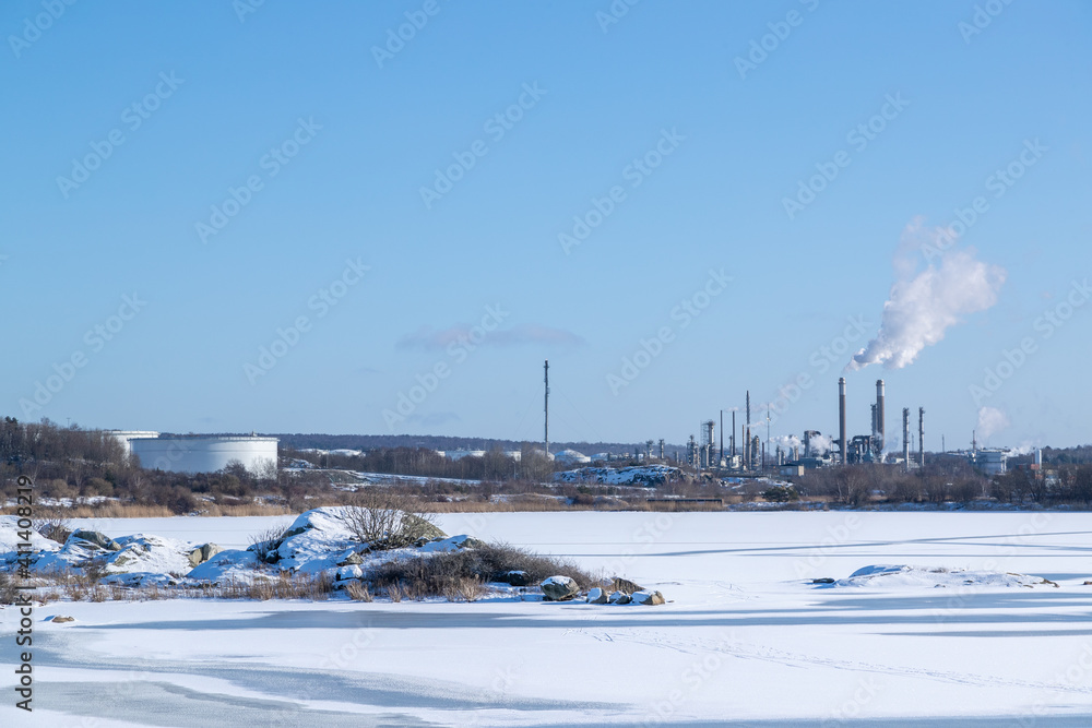 Frozen sea on a sunny winter day with chemical plants in the background. Gothenburg, Sweden 020621