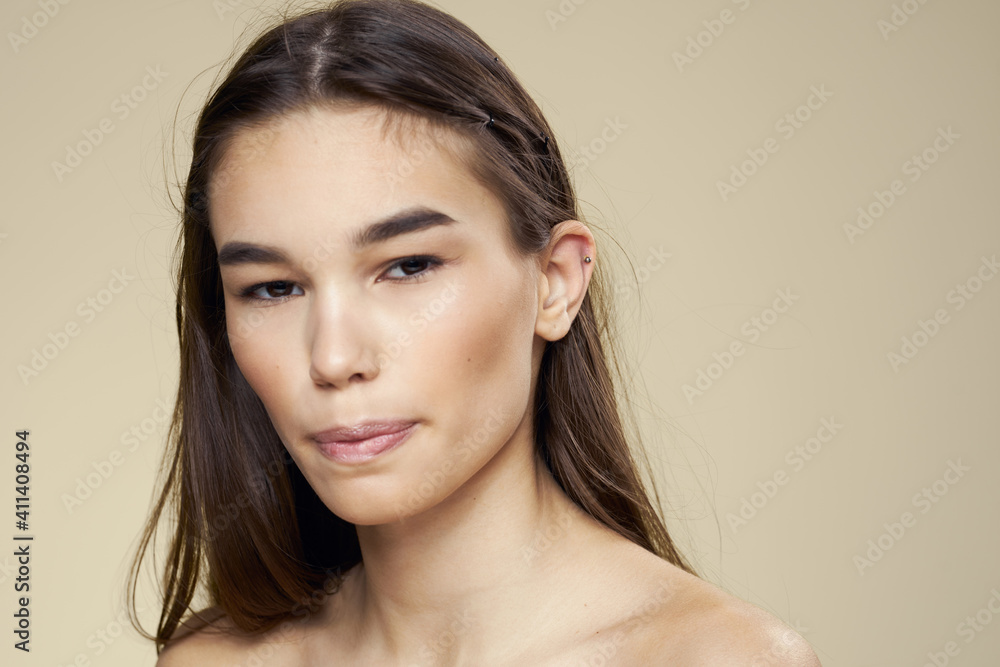 Fototapeta premium Pretty woman naked shoulders long hair body care beige background