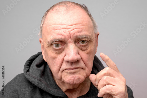 Valokuva portrait vieil homme au regard sévère sur fond gris