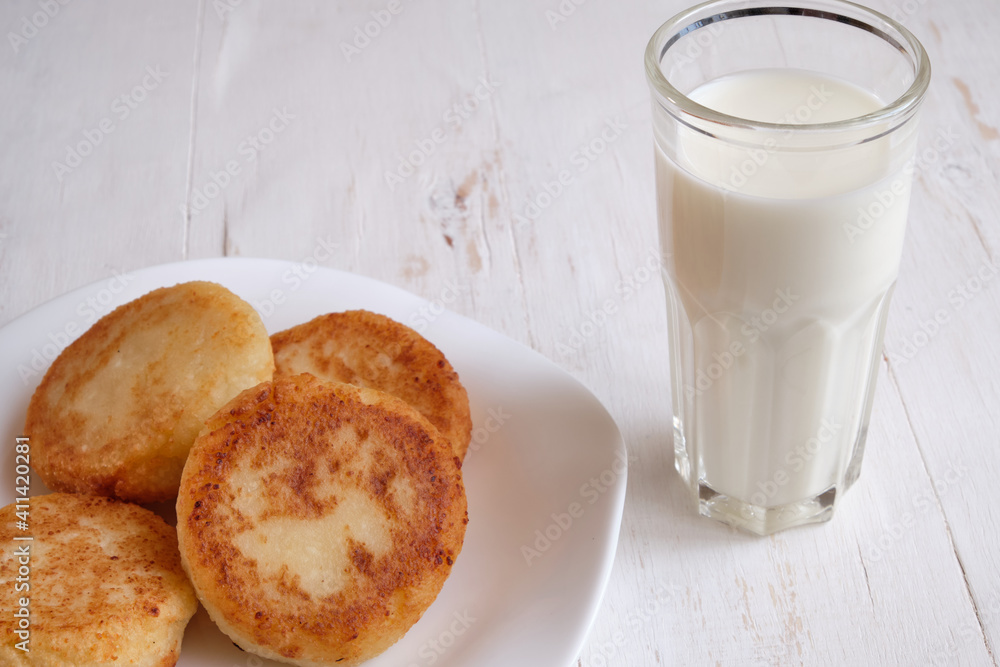 freshly baked cheesecake with milk for breakfast, on a white wooden background freshly baked cheesecake with milk for breakfast, on a white wooden background