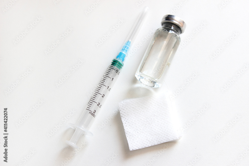 Medical layout. A bottle of vaccine and an injection syringe. The view from the top.Concept vaccination coronavirus Medical layout. A bottle of vaccine and an injection syringe. The view from the top.Concept vaccination coronavirus