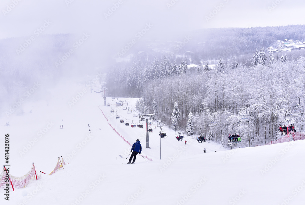 Downhill skier. Snowboarders and skier ride on snow in the mountains. Downhill ride. Adventure skiers season. Skiing and Snowboarding Resorts. Ski and snowboard equipment. Snow sports enthusiasts Downhill skier. Snowboarders and skier ride on snow in the mountains. Downhill ride. Adventure skiers season. Skiing and Snowboarding Resorts. Ski and snowboard equipment. Snow sports enthusiasts