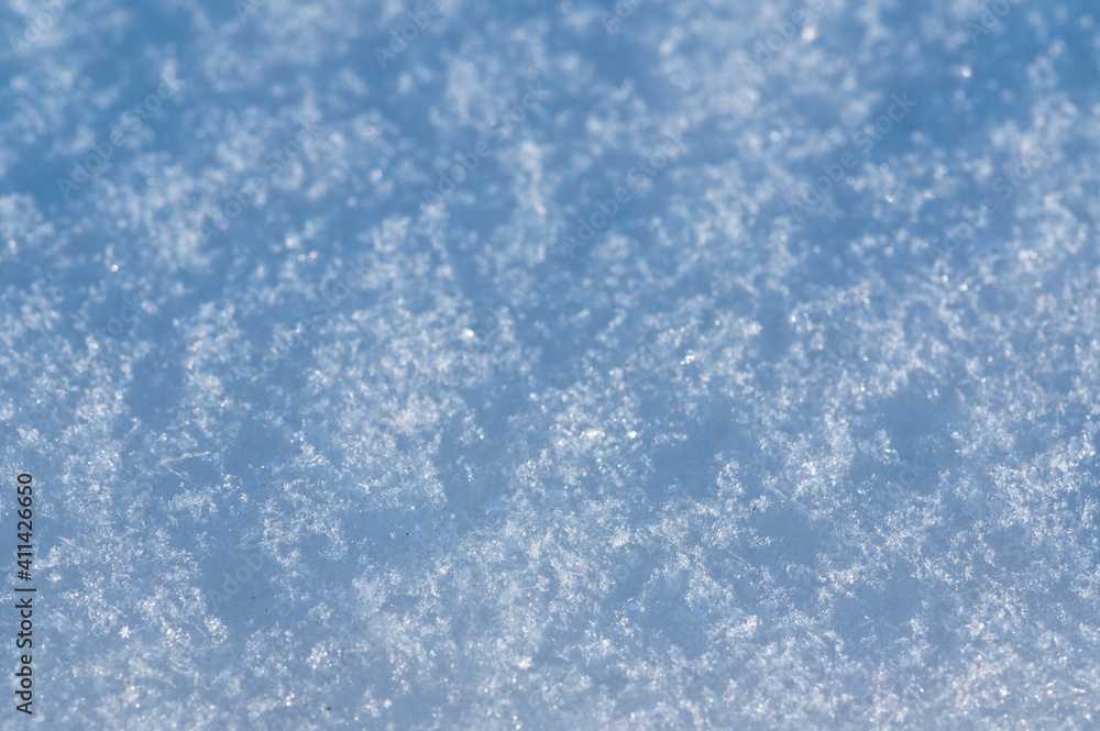 Snow close up macro photo. Background texture of a snowy surface. Cold and bright. Blurry. Out of focus