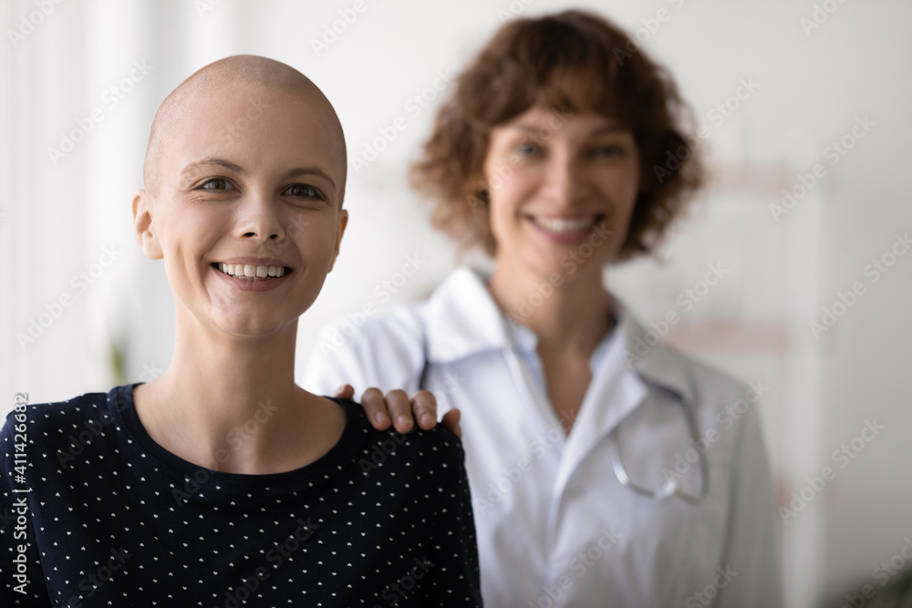 Portrait of smiling young Caucasian hairless female cancer patient beat battle disease with caring doctor. Happy GP help support optimistic bald woman overcome oncology. Recovery, remission concept. Portrait of smiling young Caucasian hairless female cancer patient beat battle disease with caring doctor. Happy GP help support optimistic bald woman overcome oncology. Recovery, remission concept.
