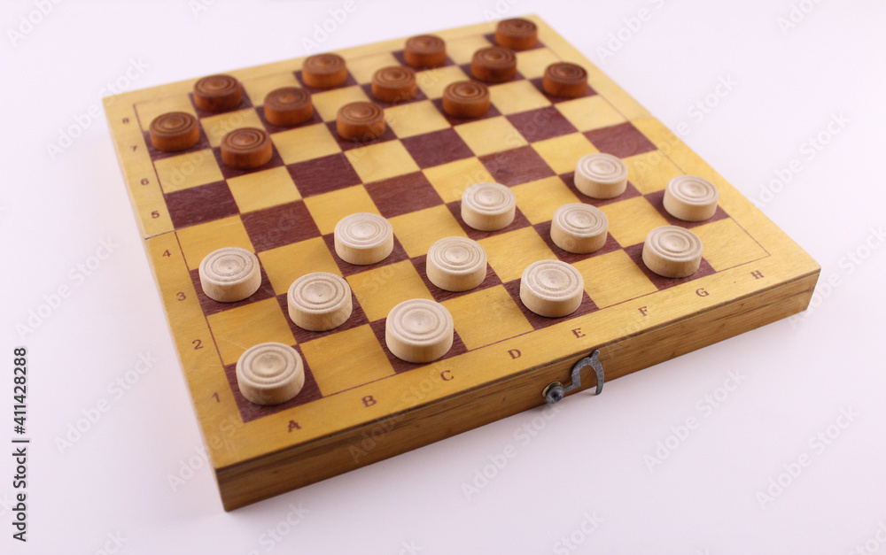 Checkers game. Wooden checkers on a blackboard on a white background Checkers game. Wooden checkers on a blackboard on a white background