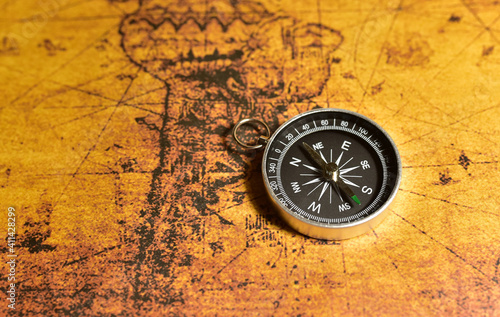 Compass on map. Tourist compass for orientation on the terrain. Magnetic declination сalculator. Historical explorer help. Map reading and land navigation concept. Orient on maps © MaxSafaniuk