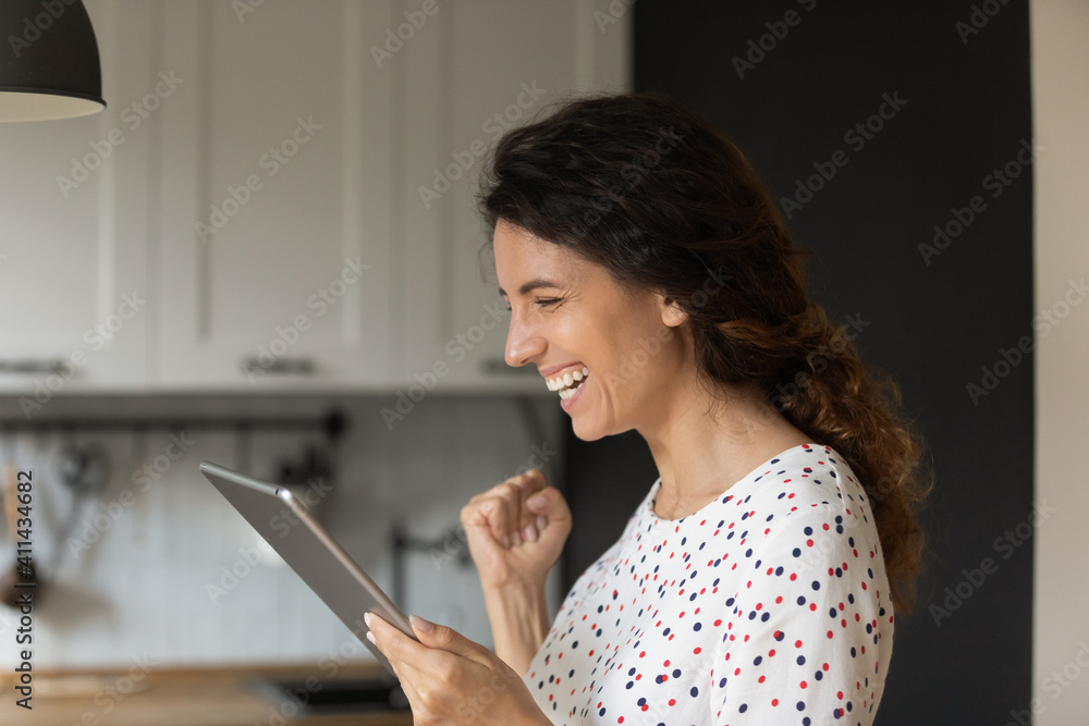 Close up of overjoyed young Caucasian woman look at tablet screen triumph win online lottery on device. Happy millennial female feel euphoric reading good pleasant news on pad gadget. Luck concept. Close up of overjoyed young Caucasian woman look at tablet screen triumph win online lottery on device. Happy millennial female feel euphoric reading good pleasant news on pad gadget. Luck concept.