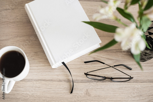 Book, coffee cup, glasses on a table. Reading, leisure, social distance, learning, hobby, relaxation, vacations, studying concept