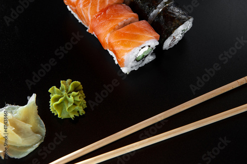 a photograph of sushi and roles on the black background