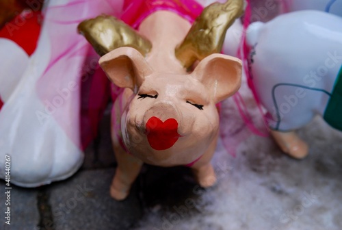small ceramic toy pig with closed eyes and red lipstick