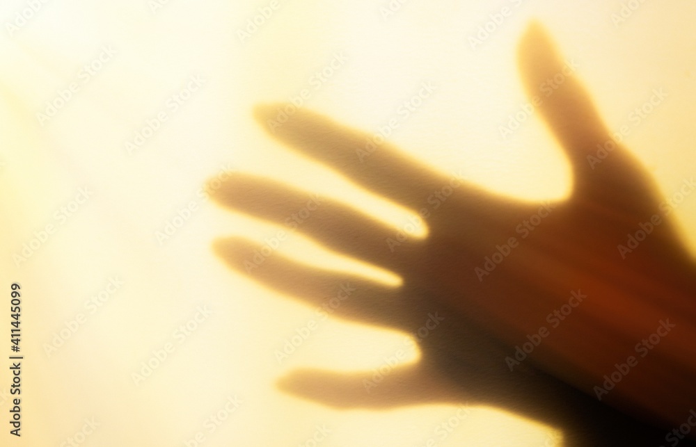 a blurred shadow of a hand on a painted wall, the shadow of a woman's hand