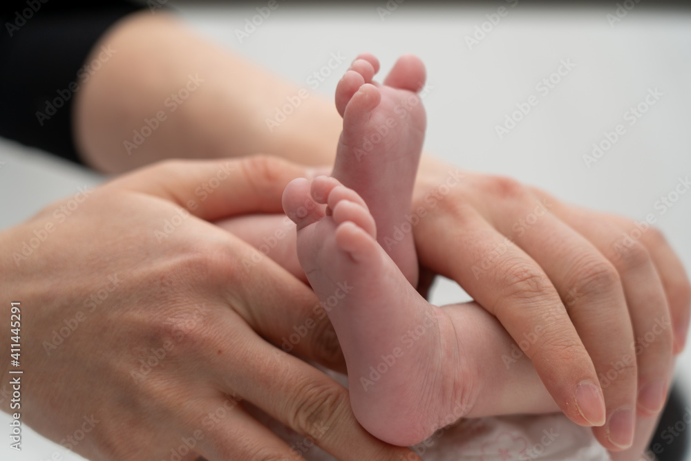 A baby's foot being held in a mother's hand_14 A baby's foot being held in a mother's hand_14
