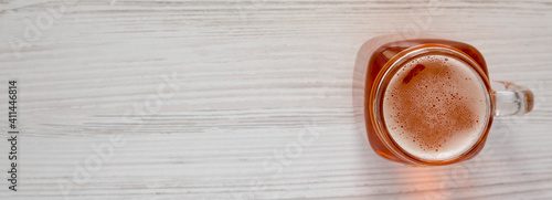 Hard Apple Cider Ale in a Glass Jar Mug on a white wooden table  top view. Flat lay  overhead  from above. Space for text.