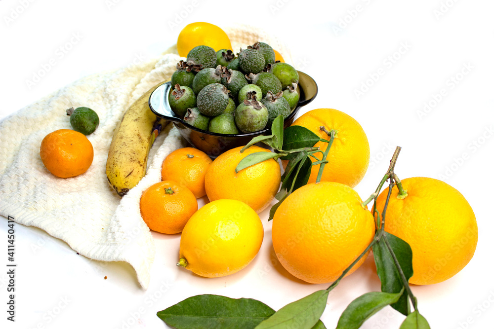 Ripe citrus fruits. Bright fresh fruit composition with foxes on a napkin. Orange, lemon, tangerine, feijoa, banana. Orange, yellow, green colors. Food market.