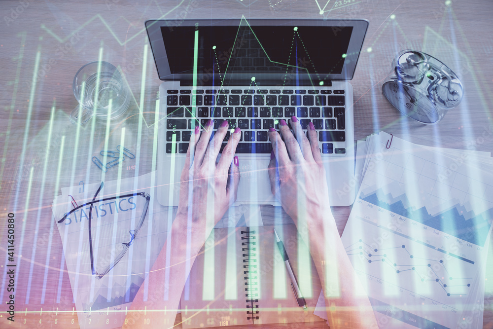 Double exposure of woman hands working on computer and forex graph hologram drawing. Top View. Financial analysis concept. Double exposure of woman hands working on computer and forex graph hologram drawing. Top View. Financial analysis concept.