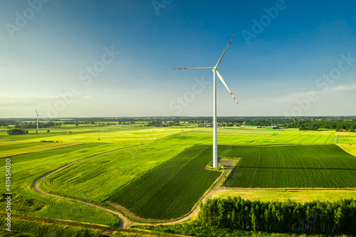 One white wind turbine on green field  aerial view