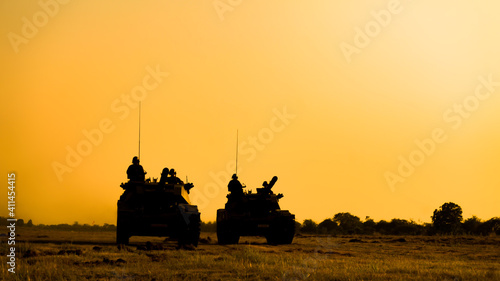 Quadro su tela Silhouettes of army soldiers in the fog against a sunset, marines team in action