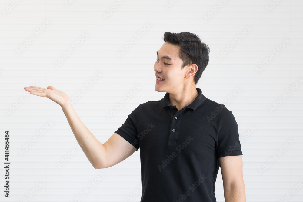 A young and cute handsome Asian man in a black shirt poses with power and full of energy. He bears his hands look like advertising and show something A young and cute handsome Asian man in a black shirt poses with power and full of energy. He bears his hands look like advertising and show something