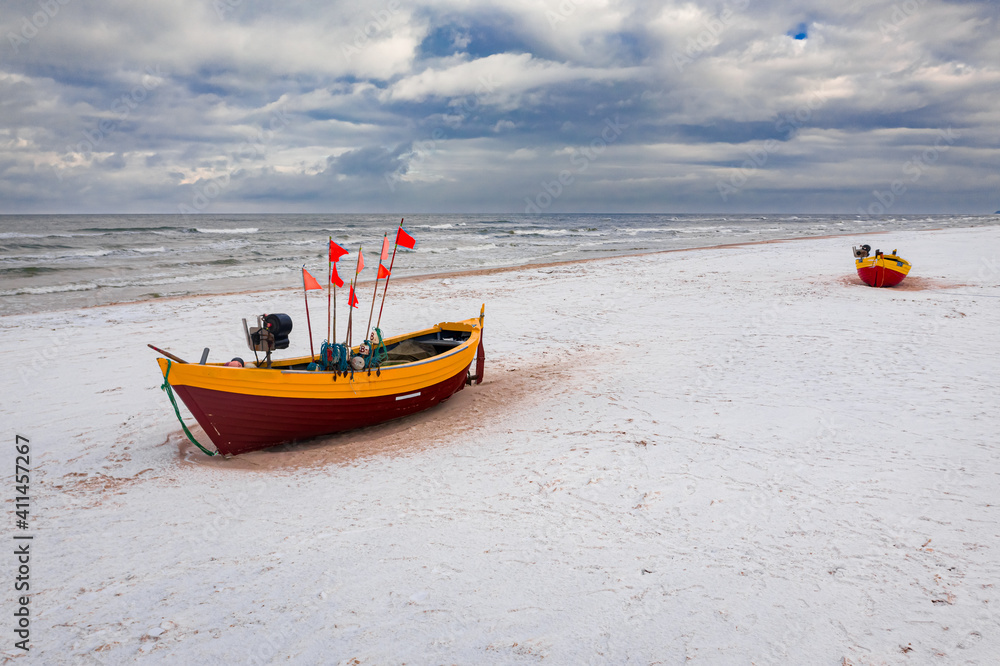 Fototapeta premium Fishing boats on snowy beach at Baltic sea in winter