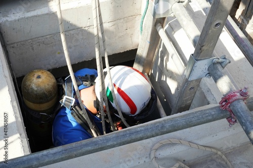 Rescue officials are going down to the concrete tank to rescue workers in confined spaces. photo