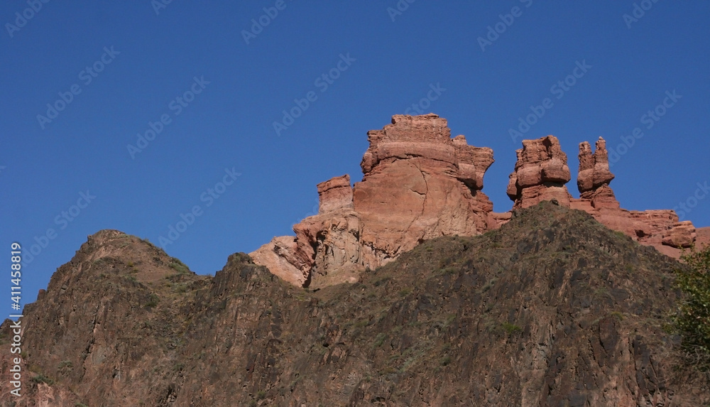 Fototapeta premium Charyn Canyon in South East Kazakhstan, summer 2019. Red rock canyon trail landscape. Trail in red rock canyon desert. Red rock canyon desert trail landscape. Yellow-red rocks of canyon in Kazakhstan.