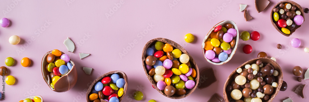 Obraz premium Festive Easter background with chocolate eggs and sweets