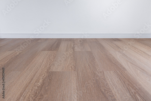 Wooden floor with white wall and floor skirting photo