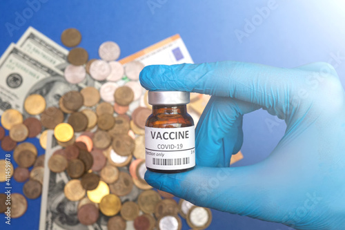 Coronavirus vaccine cost. vaccine ampoule and money. Fight against Covid-19. Pevention, immunization and treatment photo