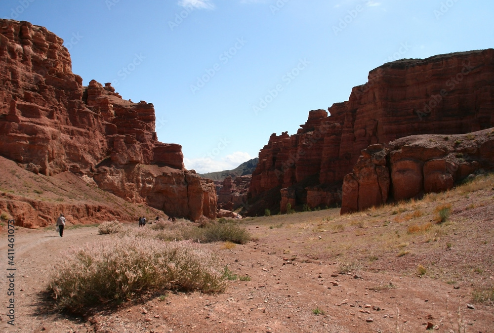 Fototapeta premium Charyn Canyon in South East Kazakhstan, summer 2019. Trail in red rock canyon desert. Red rock canyon desert trail landscape. Yellow-red rocks in Kazakhstan.