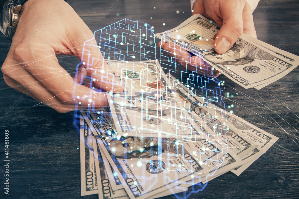 Multi exposure of brain drawing hologram and us dollars bills and man hands. Ai invest concept Multi exposure of brain drawing hologram and us dollars bills and man hands. Ai invest concept