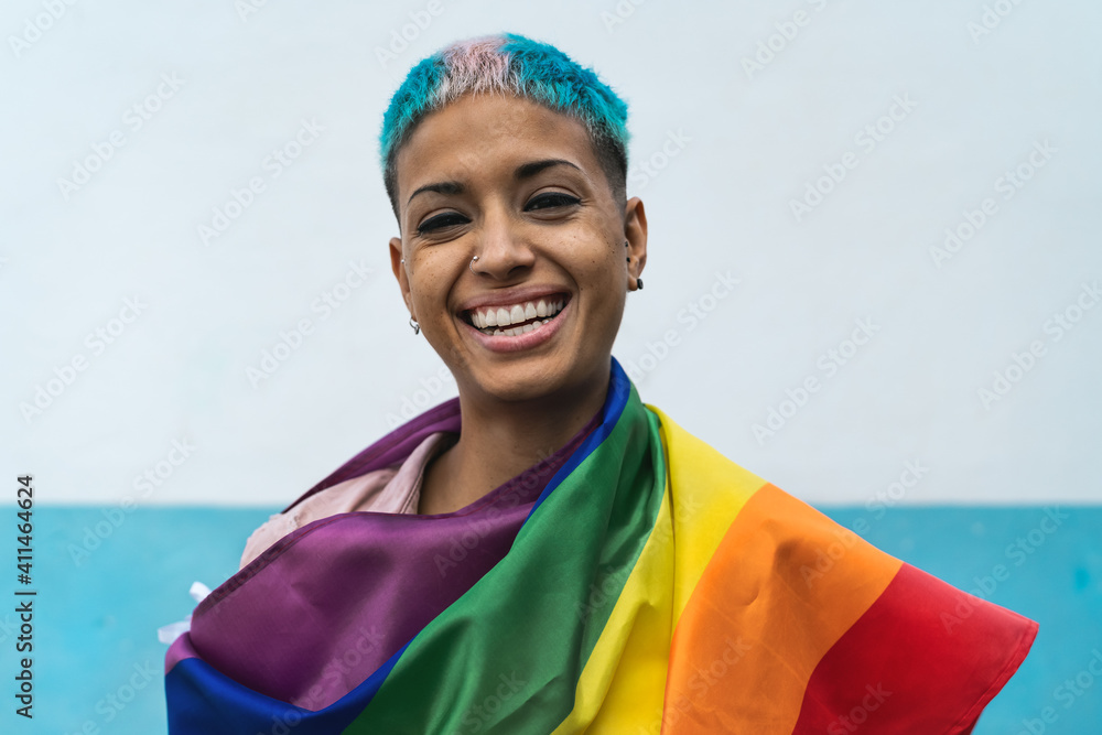 Φωτογραφία Young activist woman smiling and holding rainbow flag symbol of Lgbtq social mov