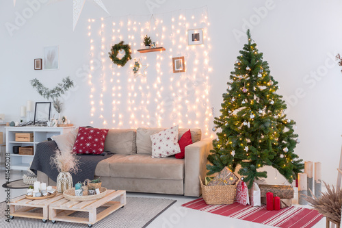 large very bright spacious stylish open plan Bali style apartment with hanging bed and panoramic windows. white floor and walls  simple wooden furniture. decorated with a christmas tree