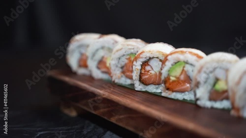 One set of Japanese salmon sushi rolls served on a wooden board
