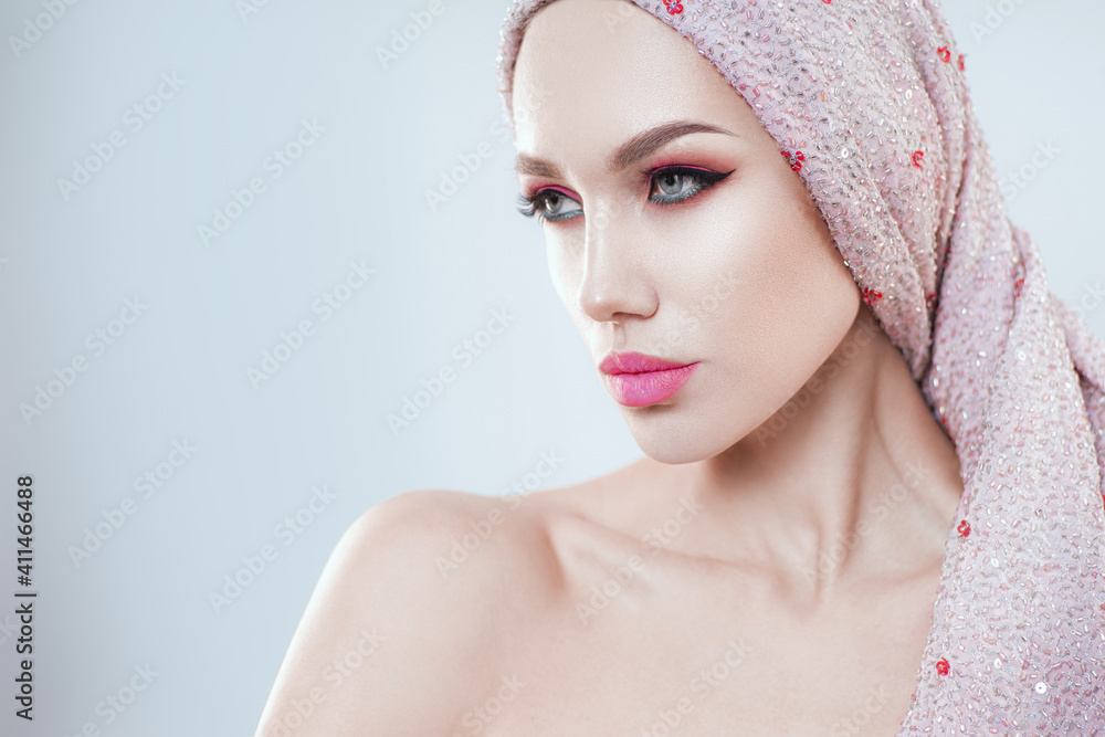 Young model posing in studio with pink makeup and shawl on head Young model posing in studio with pink makeup and shawl on head