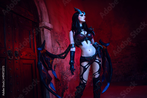 Girl devil in gothic costume and wings and horns