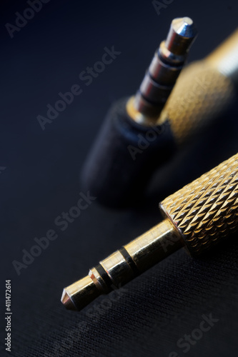 The gold-plated TRS connectors for analog audio are set against a black background. Mini-jack - 3.5 mm. Shallow depth of field photo