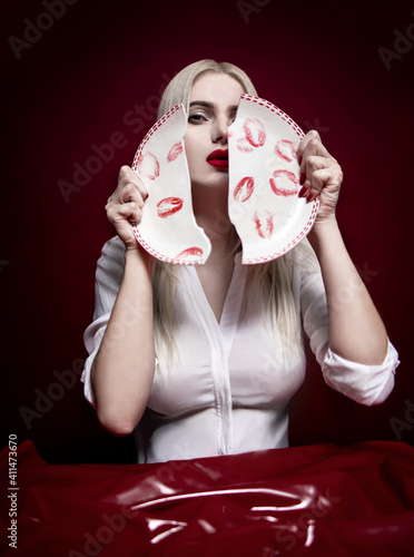 Blonde beautiful model posing with broken plate with lips print