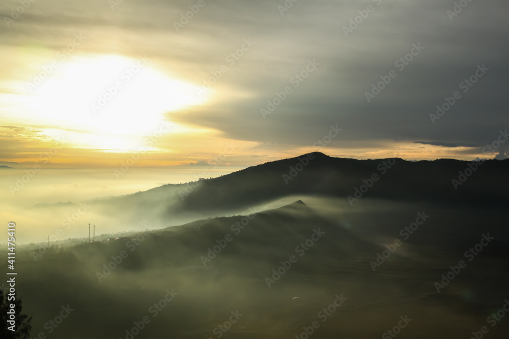 Misty valley at warm sunrise on a cloudy sky background Misty valley at warm sunrise on a cloudy sky background