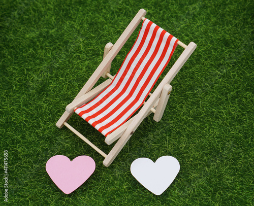 striped deck chair with two heart on a green meadow 
