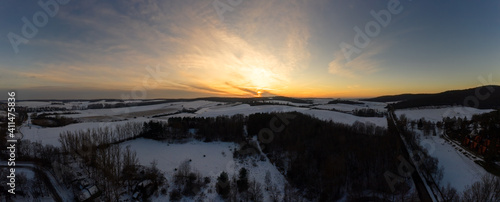Winter landscaepe with dramatic sunset. Snow covered fields and forest in a plateau. photo