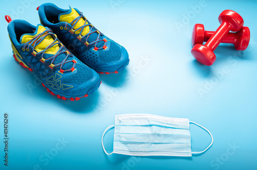 Sports equipment and medical mask. Sports sneakers and dumbbells.