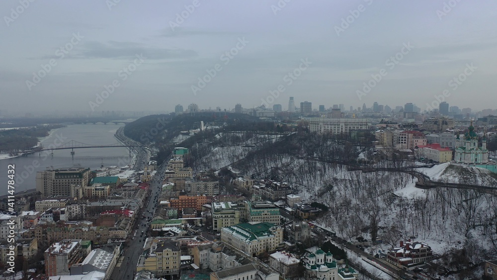 Europe, Kiev, Ukraine - February 2021: aerial view of the Podil area, St. Andrew's Church, Kontraktova Square and Kiev. Old residential buildings overlooking the city.