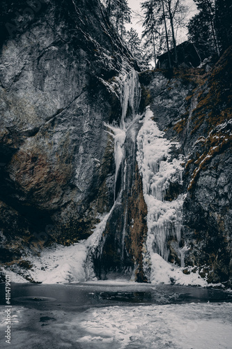 Winterlandschaft in den Bergen von Österreich mit Mühle und Wasserfall